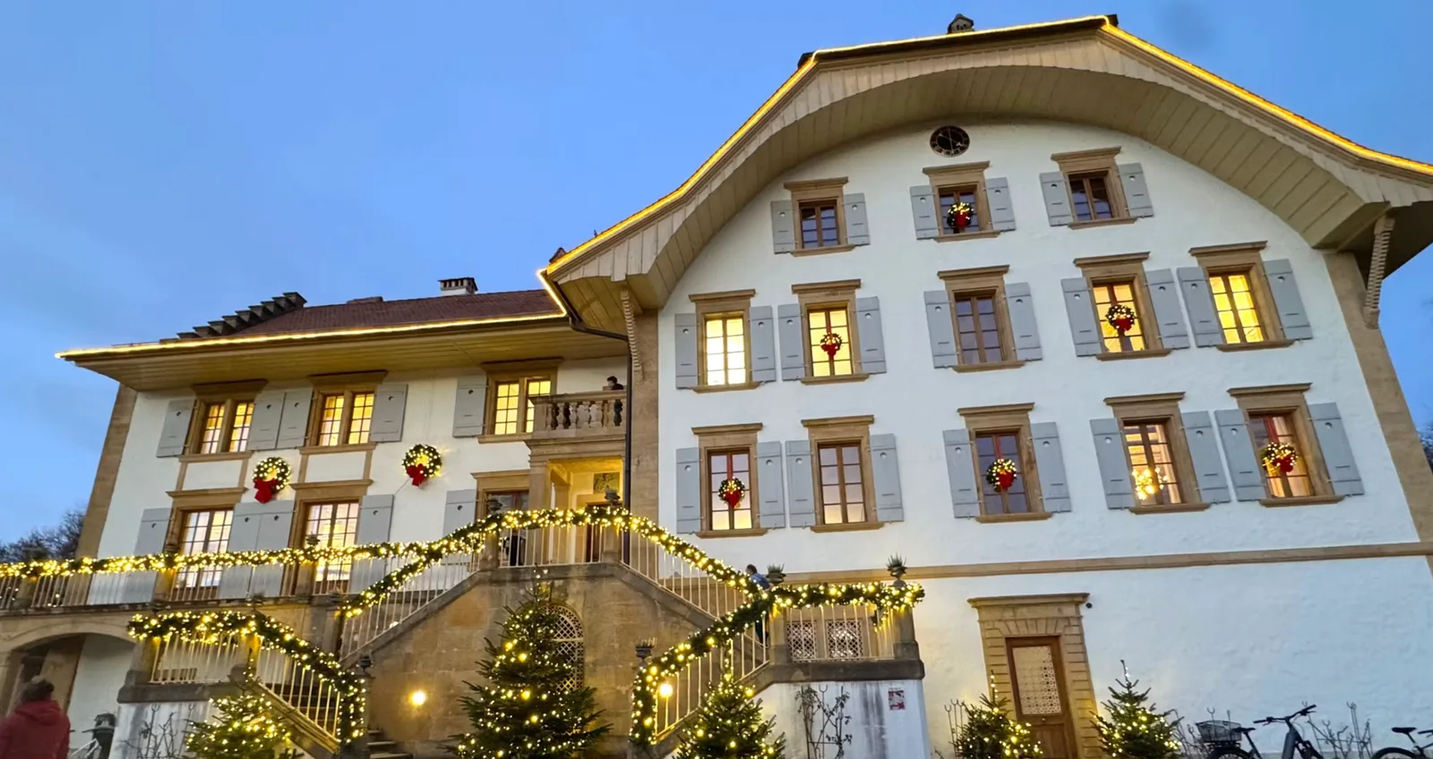Weihnachtlich beleuchtetes Herrschaftshaus Löwenberg in Murten, Schauplatz der Geschenkfabrik
